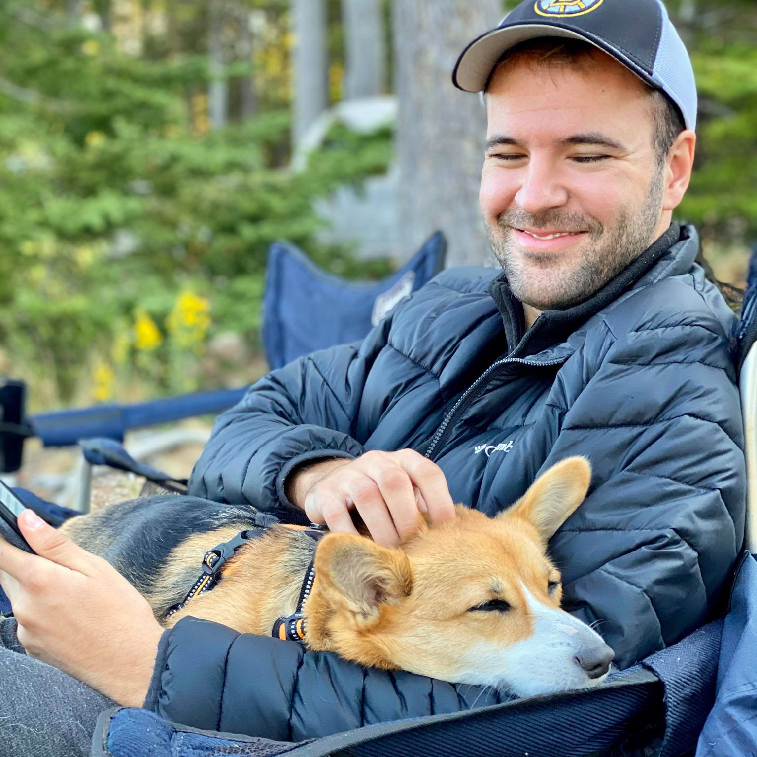 Nate Fullerton sitting on a camp chair with a corgi